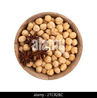 roasted hazelnuts in wooden bowl, shelled whole seeds of cobnuts or filbert nuts, macro food photo, close up from above isolated on white background w Stock Photo