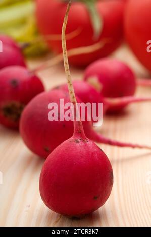 Fresh raddish and vegetables over pine wood table closeup Stock Photo