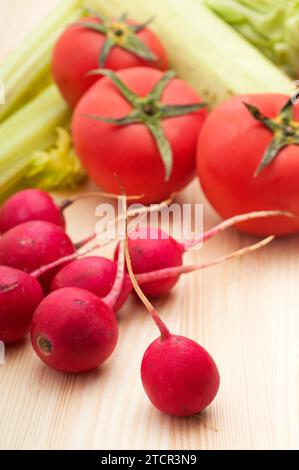 Fresh raddish and vegetables over pine wood table closeup Stock Photo