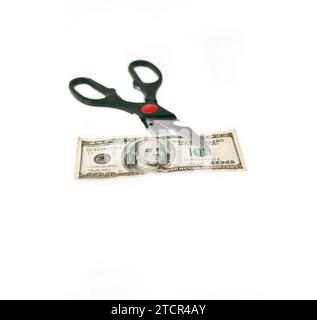 Opened stainless scissors cutting us dollar bill closeup isolated on white Stock Photo