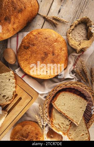 Assortment of baked bread on rustic background, flat lay Stock Photo
