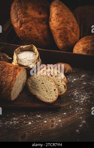 Fresh bread on wooden background. Whole and sliced breads Stock Photo