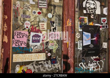 Various colourful stickers and graffiti on a window in abandoned building in the center of Moscow, Russian Federation. Stock Photo
