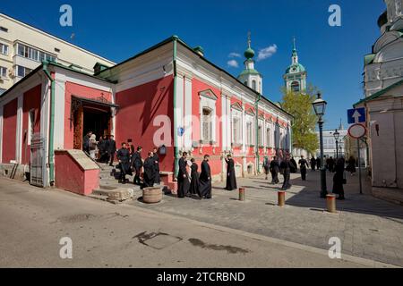 People dressed in Orthodox black robes walk out of the Church of The Beheading of John The Baptist By Bohr after religious service. Moscow, Russia. Stock Photo