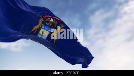 Michigan state flag waving in the wind on a clear day. Dark blue flag with state coat of arms featuring an eagle, an elk and a moose. 3d illustration Stock Photo