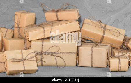 Presents on dark gray textured table background. Brown gift boxes decorated with crafter paper Stock Photo