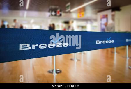 Charleston, US, Nov. 28 2023: Selective focus on a blue textured Breeze Airways branded ribbon used as a queue divider at an airport terminal, with bl Stock Photo