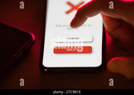 Clicking on red delete button on smartphone app Stock Photo