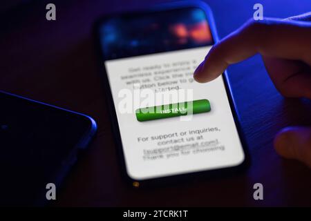Clicking on green install button on smartphone Stock Photo