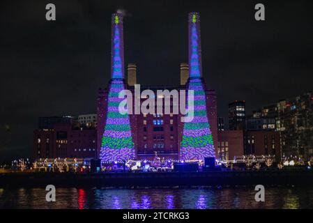 London, UK. 13th Dec, 2023. British artist David Hockney projects two animated Christmas trees onto the iconic chimneys of the Battersea Power Station in London. British capital, London is very famous around the world about its Christmas lights, markets and iconic buildings. Credit: SOPA Images Limited/Alamy Live News Stock Photo