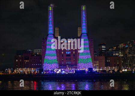 London, UK. 13th Dec, 2023. British artist David Hockney projects two animated Christmas trees onto the iconic chimneys of the Battersea Power Station in London. British capital, London is very famous around the world about its Christmas lights, markets and iconic buildings. (Photo by Krisztian Elek/SOPA Images/Sipa USA) Credit: Sipa USA/Alamy Live News Stock Photo