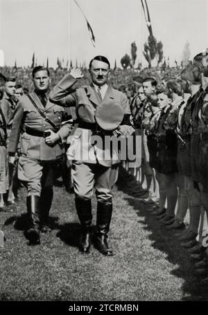 Adolf Hitler is seen at the 1934 'Parteitag der Macht' (Rally of Power) in the stadium, surrounded by the youth. This image captures a moment during one of the significant Nazi Party rallies, emphasizing the regime's focus on engaging and indoctrinating the younger generation. The stadium setting, filled with young supporters, underscores the scale of these events and the importance placed on youth participation as a means of showcasing the regime's strength and influence. Stock Photo