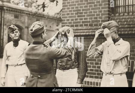 German recruits, newly arrived at their military camp, are captured trying on their new military caps for the first time. This moment marks a significant step in their transition into military life, symbolizing the beginning of their journey as soldiers. Stock Photo