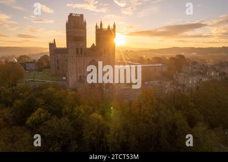 Sun rising behind Durham Cathedral in Durham, County Durham on a stunning autumn morning with lens flare through the Cathedral towers. Stock Photo