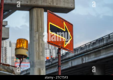 Traffic sign with flags reading utilitary. Electronic arrow pointing to the right to divert traffic Stock Photo