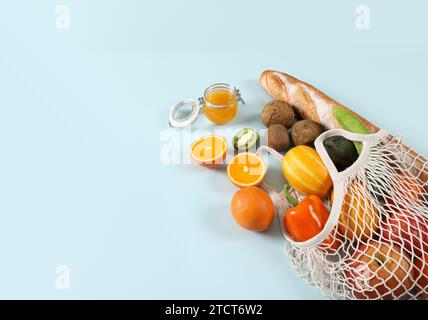 Grocery ingredients in a net bag are isolated on a solid background. Stock Photo