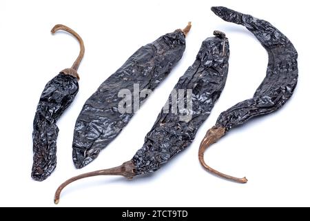 Four Pasilla Dried Black Chillies on a White Background Stock Photo