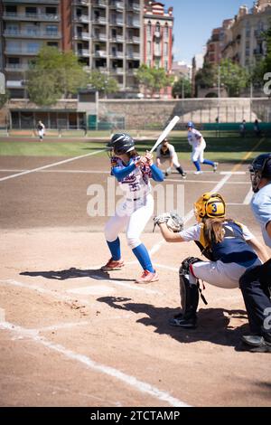 Valencia, Spain - May 14, 2023: A female batter ready to hit the ball and the catcher behind tries to catch it in a baseball match in the Turia river Stock Photo