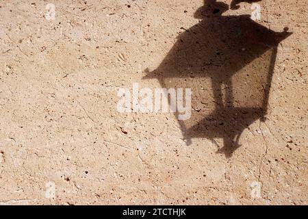 Black shadow of old street lamp on yellow wall closeup pattern. Stock Photo