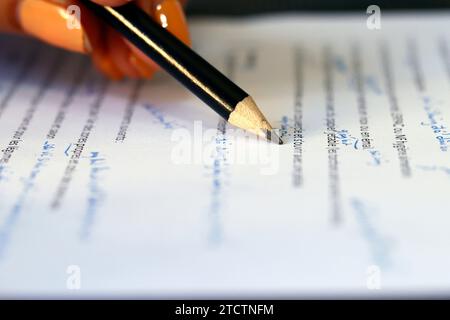 Close-up view of pencil on text of paper document. Stock Photo