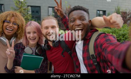 Diverse multiracial college university friends happy gen z multiethnic people teens students smiling record video blog vlog influencer posing for Stock Photo