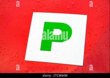 Green probationary driver P plate on a red car Stock Photo