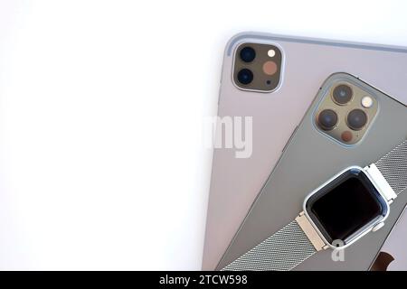 KYIV, UKRAINE - 4 MAY, 2023: Apple brand devices iphone, ipad with apple watch lies on macbook body close up Stock Photo