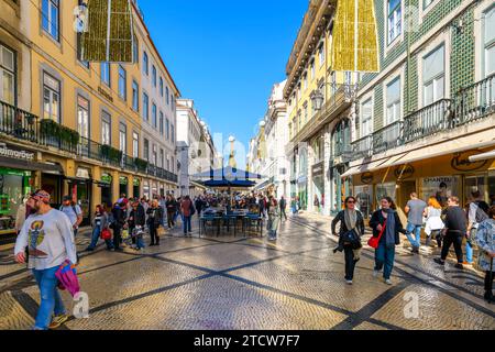 The popular Rua Augusta street, full of shoppers and diners enjoying the stores, restaurants and sidewalk cafes in Lisbon, Portugal. Stock Photo