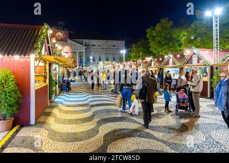 Evening view of holiday decorations and food booths at the Rossio Christmas Market in the Baixa district of Lisbon, Portugal. Stock Photo