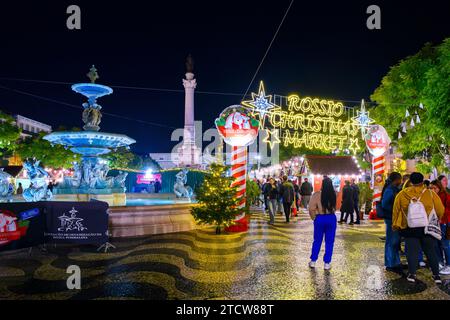 Evening view of holiday decorations and food booths at the Rossio Christmas Market in the Baixa district of Lisbon, Portugal. Stock Photo