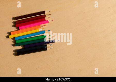 colored pencils: vibrant assortment neatly arranged on a wooden table, ready to unleash creativity with their range of vibrant colours. Stock Photo