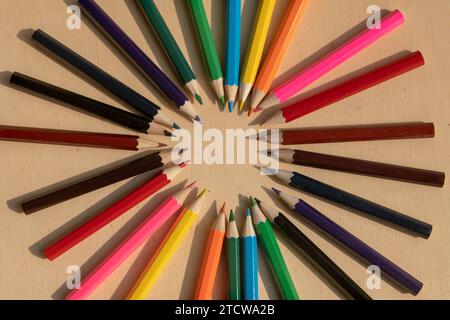 colored pencils: vibrant assortment neatly arranged on a wooden table, ready to unleash creativity with their range of vibrant colours. Stock Photo