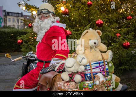 Cottbus, Germany. 14th Dec, 2023. A man dressed as Santa Claus stands in front of an illuminated Christmas tree on his vintage motorcycle. Credit: Frank Hammerschmidt/dpa/Alamy Live News Stock Photo