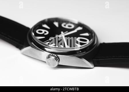 Automatic mechanical wrist watch with bold white numerals on black clock face in steel case, close up studio photo over white background Stock Photo