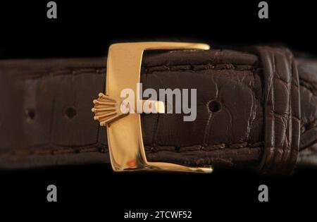 Wristwatch strap with golden Rolex logo. Close up image isolated on black background. Copenhagen, Denmark - October 12, 2023. Stock Photo