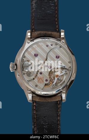 Back of  Venturer Big Date Purity Blue Fume wristwatch with gears and cogs from H. Moser & Cie. Swiss luxury watch manufacturer. Isolated on blue back Stock Photo