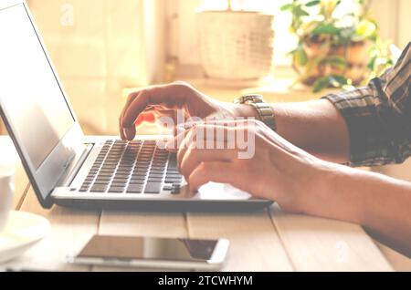 Laptop, phone. Programmer's hands working on laptop keyboard. Stock Photo
