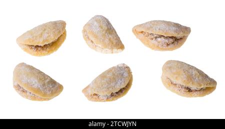 Set of sweets with yummy nut filling in shell shape isolated on white background. Closeup of delicious traditional Christmas or wedding walnut cookies. Stock Photo