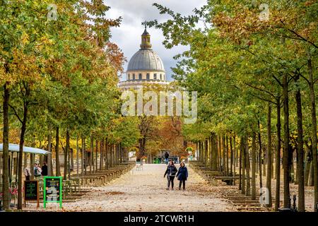 Two woman walking along a tree lined path in the autumn at The Jardin du Luxembourg with the dome of the Panthéon in the background, Paris,France Stock Photo