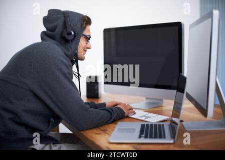 Man, hoodie and hacker on computer for digital information for password error, cyber security or database glitch. Male person, dual screen and online Stock Photo