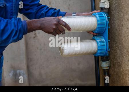 African plumber replaces the water filters. Clean water concept. Stock Photo