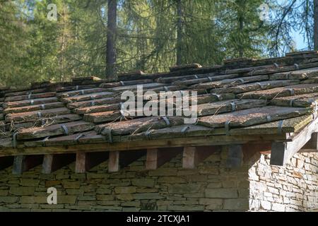 mountain roof, clad in stone slabs, the details capture the rustic essence while integrating with the surrounding environment. log cabin, house. Stock Photo