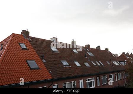 Beautiful building with tiled roof and chimneys in city under sky Stock Photo