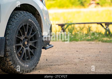 Close-up of a rugged off-road tire on a vehicle in a Grand Lake, Colorado parking lot. Stock Photo