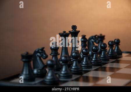 initial setting of black chess pieces before the start of a chess game, in a photo with a dark background Stock Photo