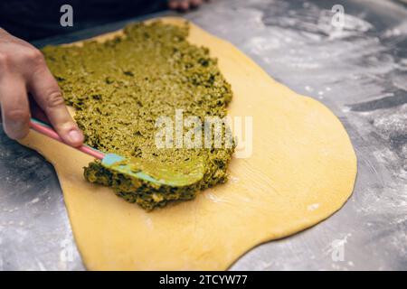 Baker make stuffed sweet bread. Dough with pistachio filling. Stock Photo