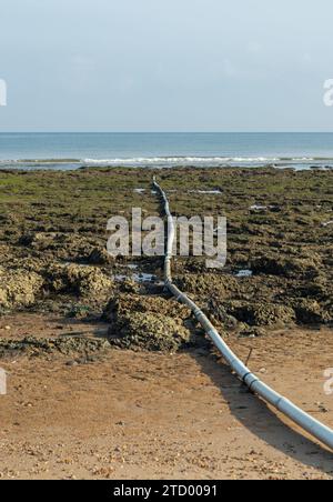 Dirty sewage from the pipe which flows into the sea, environmental pollution Stock Photo
