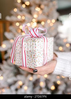 Hands In Sweater Holding A Gift On Wooden Table With Christmas hands-in-sweater-holding-a-gift-on-wooden-table-with-christmas
