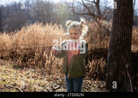 Child opening seed pod watching seeds fly out Stock Photo
