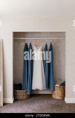 Wedding dress, and bridesmaids dresses hanging on novelty wooden coat ...